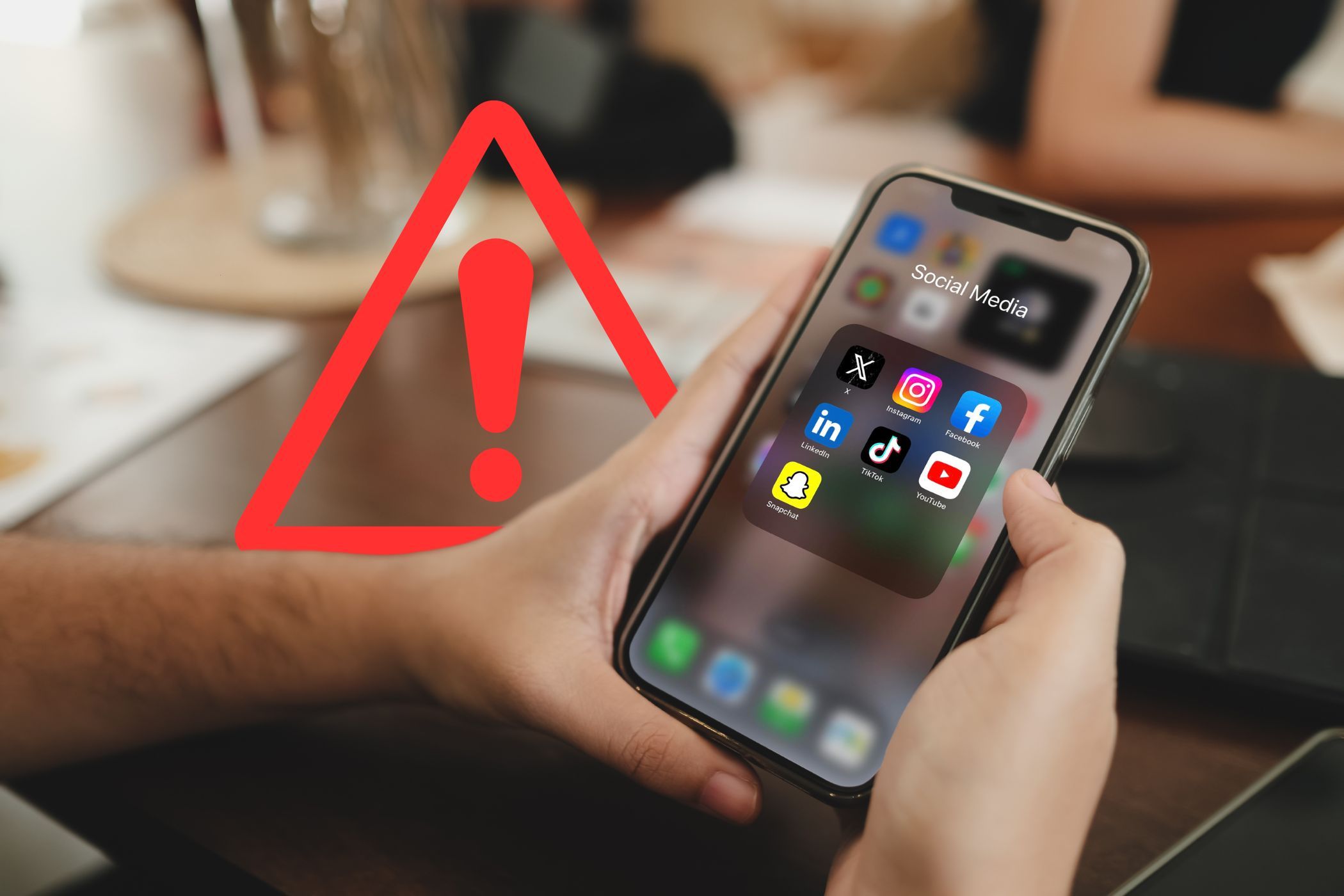 social media apps on a smartphone screen with a warning icon